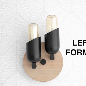 May include: Two black wall sconces with clear glass bulbs mounted on a round wooden base.  LEFT FORMAT