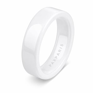 May include: A white ceramic ring with a flat top and rounded edges. The ring has a glossy finish and the text "PAXPARIS" is subtly printed on the inside. The ring is a simple, modern design.