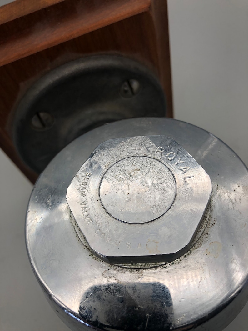 May include: Close-up of a silver metal valve with the text "SLOAN VALVE CO. U.S.A." and "ROYAL" printed on the top.