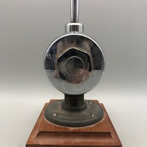 May include: A chrome-plated valve with a wooden base. The valve has a round body with a lever handle and the text "WATER CO.  PAT.  NO.  1,545,010" on the side.
