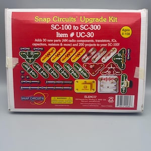 May include: A red and white Snap Circuits Upgrade Kit box. The box includes the text "SC-100 to SC-300" and "Item # UC-30". It adds 30 new parts and 200 projects. The kit is for ages 8-108.