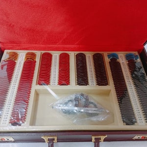 May include: A brown leather case with a red velvet lining, containing a set of eyeglass lenses in a variety of powers. The lenses are organized in rows and columns, and there is a small tool for adjusting the lenses.