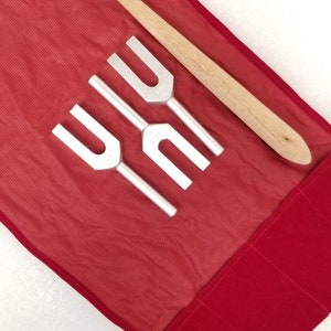 May include: A set of three tuning forks with a wooden mallet in a red velvet carrying case.