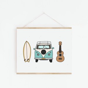 May include: A framed print featuring a blue and white vintage van, a surfboard, and a ukulele. The van has a black circle on the side and a surfboard is on the roof. The print has a white background with a subtle speckled pattern.