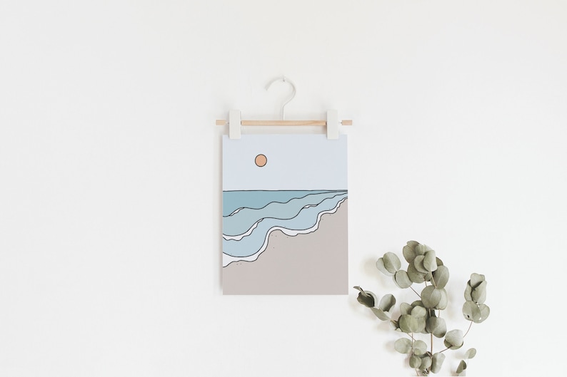 May include: A minimalist line art print of a beach scene with blue waves and a setting sun. The print is hanging on a white wall with a wooden dowel and white clips.