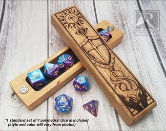 Pode incluir: Caixa de dados de madeira com design gravado de sol e escudo. A caixa está aberta, revelando um conjunto de sete dados de várias faces em tons de azul, roxo e dourado. O texto na caixa diz "RAVENWORKS".