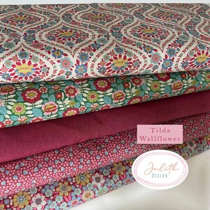 Könnte beinhalten: Ein Stapel Stoffe mit Blumenmuster in verschiedenen Farben. Die oberste Schicht hat einen weißen Hintergrund mit einem sich wiederholenden Muster aus roten, blauen und gelben Blumen. Weitere Schichten umfassen grüne, rosa und bordeauxfarbene Stoffe. Der Text "Tilda Wallflower" und "Julith Design" sind sichtbar.