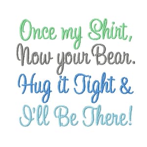 Op de afbeelding: Borduurwerk met de tekst "Once my Shirt, Now your Bear. Hug it Tight & I'll Be There!" in groen, grijs en blauw.