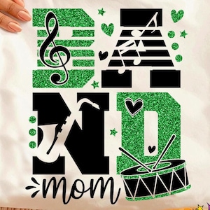 Puede incluir: Sudadera blanca con un diseño de purpurina verde que dice "BAND MOM". El diseño incluye notas musicales, una clave de sol, un saxofón, un tambor y corazones. La parte inferior de la sudadera tiene las palabras "SVG + DXF + EPS + PNG + JPG".