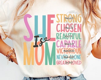Puede incluir: Un diseño gráfico colorido con el texto "SHE IS MOM" y una lista de palabras que describen a una mujer, incluyendo "fuerte", "elegida", "hermosa", "capaz", "victorioso", "nunca sola" y "amada". Cada palabra está emparejada con un versículo de la Biblia.