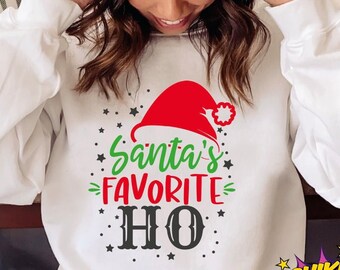 May include: White sweatshirt with the text "Santa's FAVORITE HO" in green, red, and black. The design includes a Santa hat and stars. The image also includes the text "SVG + DXF + EPS + PNG + JPG".