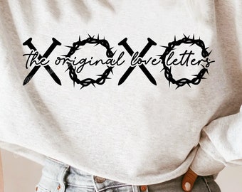 May include: A white sweatshirt with the text "XOXO the original love letters" in black. The letters are surrounded by a thorny crown design.