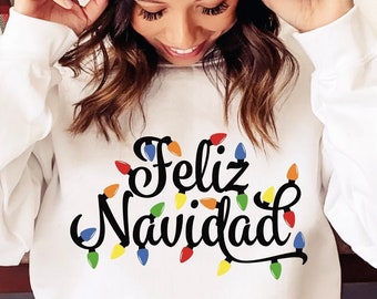 May include: A white sweatshirt with the text "Feliz Navidad" in black script with colorful lightbulbs surrounding the text.