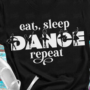 May include: A black t-shirt with white text that reads "eat, sleep, DANCE, repeat" with silhouettes of ballerinas in the word "DANCE".