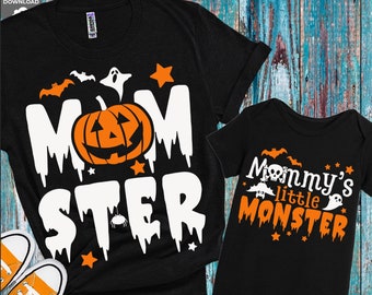 May include: A black t-shirt with the text "MOM STER" in white with a dripping effect. A pumpkin with a jack-o-lantern face is in the center of the text. A black onesie with the text "Mommy's little MONSTER" in orange and white. Both shirts have a Halloween theme with bats, stars, and ghosts.