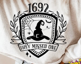 May include: A black and white graphic design featuring a witch's hat with a spider web and the text "1692 They Missed One".