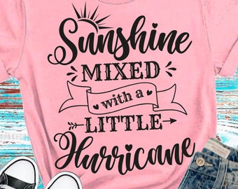 May include: Pink t-shirt with a black graphic that says "Sunshine Mixed with a Little Hurricane".