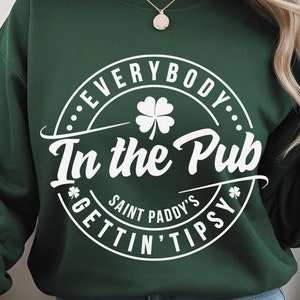 May include: Green sweatshirt with a white circle design that says "Everybody. In the Pub. *Gettin' Tipsy* Saint Paddy's" with a four-leaf clover inside the circle.