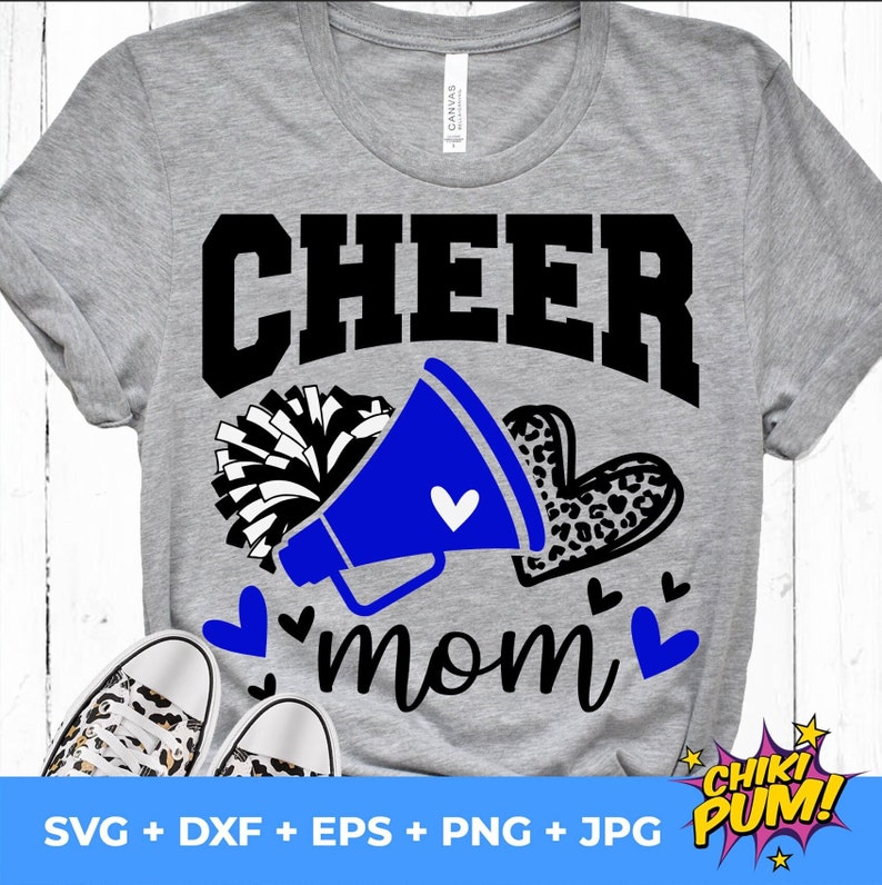 May include: A gray t-shirt with the text "CHEER mom" in black. A blue megaphone with a white heart is next to the text. A black and white pom-pom is behind the megaphone. A leopard print heart is next to the megaphone. There are small hearts around the text.