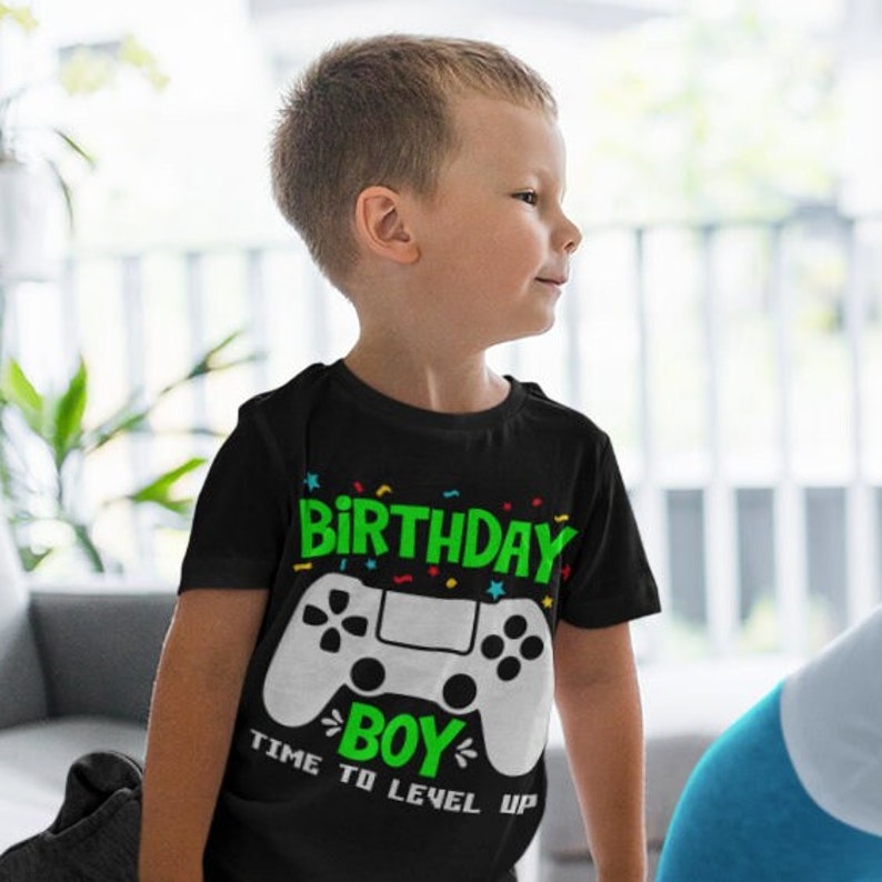 May include: A black t-shirt with a green and white video game controller graphic. The text "Birthday Boy" and "Time to Level Up" are printed on the shirt.