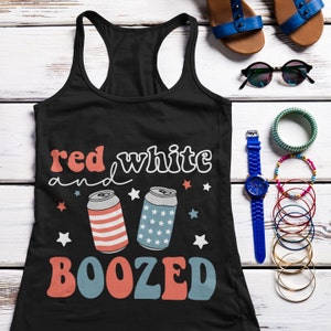 Pu&ograve; includere: Canotta nera con un design grafico rosso, bianco e blu. La grafica presenta due lattine di birra con stelle e strisce e il testo "red white and boozed".