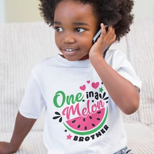 May include: A white t-shirt with a watermelon graphic and the text "One in a Melon Brother".
