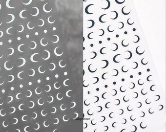 May include: Two sheets of nail art decals featuring crescent moon and dot designs. One sheet has white moons and dots on a gray background. The other has black moons and dots on a white background. The brand name "Gelapressed" is visible.