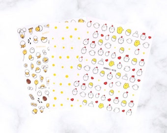 May include: Sheets of white stickers with yellow, red, and black cartoon illustrations of eggs, chickens, and hearts. The stickers have a variety of designs, including eggs with faces, chickens with hats, and small hearts. The text "HANYI-410" is printed on one sheet.