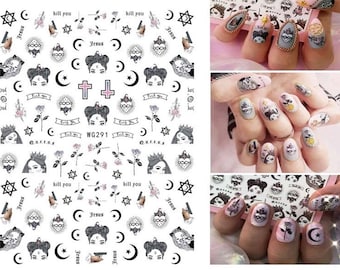 May include: Nail art stickers featuring various black and white gothic-inspired designs. The sheet includes images of faces, roses, moons, stars, crosses, and the text "Jesus", "kill you", and "fuck you". The nail art is shown applied to nails.