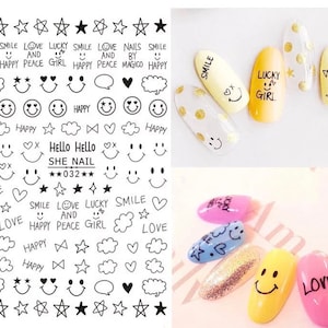 May include: Nail art stickers with black and white designs, including stars, smiley faces, hearts, and text like "SMILE", "LOVE", and "HAPPY". Several painted nails feature similar designs, with text like "SMILE" and "LUCKY GIRL".