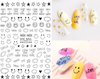 May include: Nail art stickers with black and white designs, including stars, smiley faces, hearts, and text like "SMILE", "LOVE", and "HAPPY". Several painted nails feature similar designs, with text like "SMILE" and "LUCKY GIRL".
