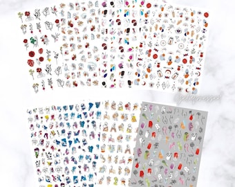 May include: A collection of nail art sticker sheets featuring various designs. The sheets display colorful abstract art, flowers, faces, and other small illustrations. The text "Gelapressed" is visible in the image.