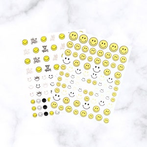May include: Sheets of yellow smiley face stickers in various sizes and designs. Some stickers have text that reads "Wake Up Smile" and "Now or Never". Other stickers have different facial expressions.