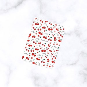 May include: A sheet of nail art stickers featuring a repeating pattern of red cherries with green stems and leaves on a white background. The text "HANYI-330" is visible. The word "Cherry" is also visible.
