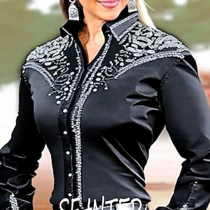 May include: A black satin shirt with silver embellishments and a button-up front. The shirt has a pointed collar and long sleeves.