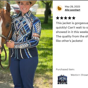 Peut inclure: Une femme portant une veste de showmanship bleue et blanche avec des motifs g&eacute;om&eacute;triques et des strass se tient &agrave; c&ocirc;t&eacute; d'un cheval brun. La veste a un col noir et des manches longues. La femme porte un pantalon bleu. Le cheval a une &eacute;toile blanche sur le visage. Le texte "Western Showmanship Jacket, Western S..." est visible sous l'image.