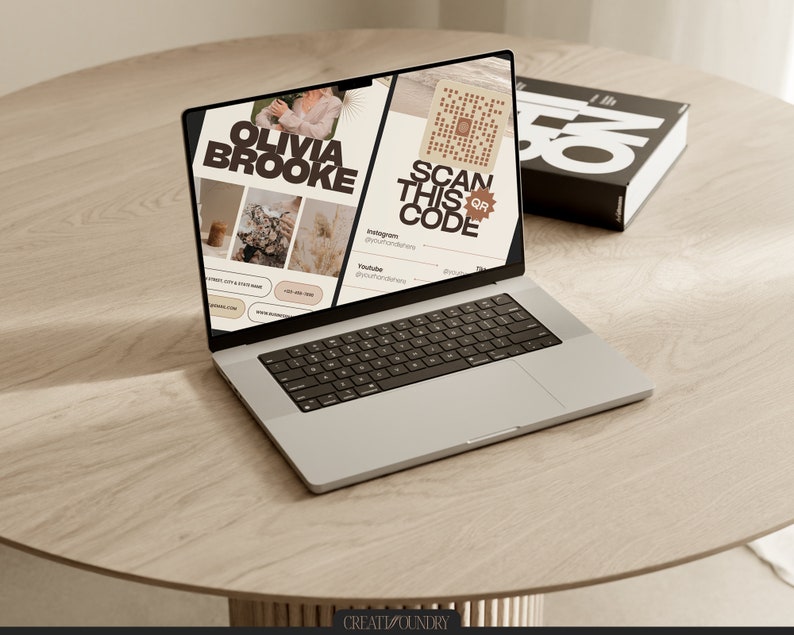 May include: A laptop computer open to a website with the text "Olivia Brooke" and "Scan this QR code". The website has a light brown background with images of a woman, a coffee cup, and a plant. The laptop is on a light brown wooden table.