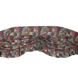 May include: A brown and green valance with a floral pattern of grapes and leaves. The valance has a ruffled edge.