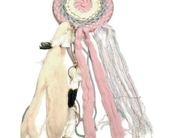 May include: A pink, white, and gray woven wall hanging with feathers and tassels. The hanging is circular and has a macrame design.