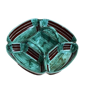 以下が含まれることがあります： ユニークな形状と仕切られたコンパートメントを持つ、装飾的なセラミック製のサービングディッシュ。 皿は、ティールグリーンのベースカラーに、ダークブラウンのアクセントとストライプが特徴です。 全体的なデザインは幾何学的で芸術的です。