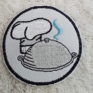 May include: White embroidered patch with a chef's hat and a silver cloche with a blue steam coming out of it.