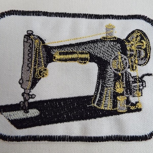 May include: Embroidered patch featuring a vintage sewing machine design. The machine is black with gold and gray accents, set against a white background. The patch has a black border, suitable for sewing or ironing onto fabric.