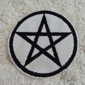 以下が含まれることがあります： 白い円形のワッペンに黒い五芒星が刺繍されている