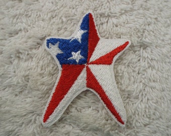 Pode incluir: Um remendo bordado em forma de estrela nas cores vermelho, branco e azul com o design da bandeira americana.