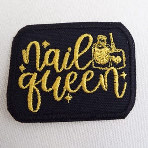 May include: Black embroidered patch with gold thread. The patch says "nail queen" with a stylized image of a nail polish bottle.