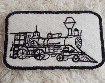 May include: Black and white embroidered patch of a vintage steam locomotive train on a white canvas background with a black border.