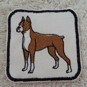 May include: Embroidered patch featuring a brown and white boxer dog with black outlines. The patch is square and has a black border.
