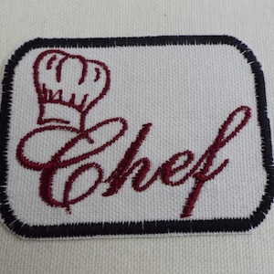 Può includere: Toppa ricamata con un cappello da chef rosso e la parola "Chef" in corsivo.