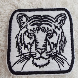 May include: Black and white embroidered iron-on patch of a tiger's face.