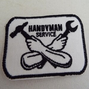 May include: White embroidered patch with black stitching. The patch features a crossed wrench and hammer with the text "Handyman Service".